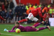 Dynamic soccer match with players competing intensely for the ball on the field.