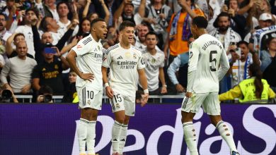 Real Madrid football team celebrating a goal with fans cheering in the stadium.