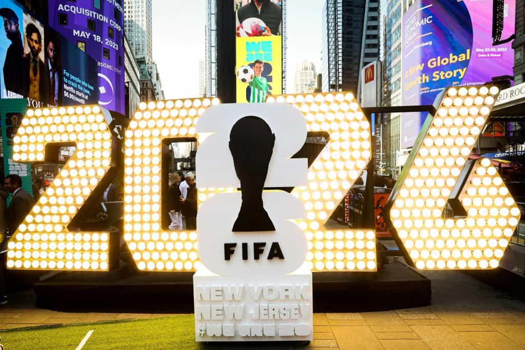 Colorful FIFA World Cup 2023 signage in Times Square, New York, with bright lights, billboards, and bustling crowd, showcasing international football excitement and major sports event highlights.