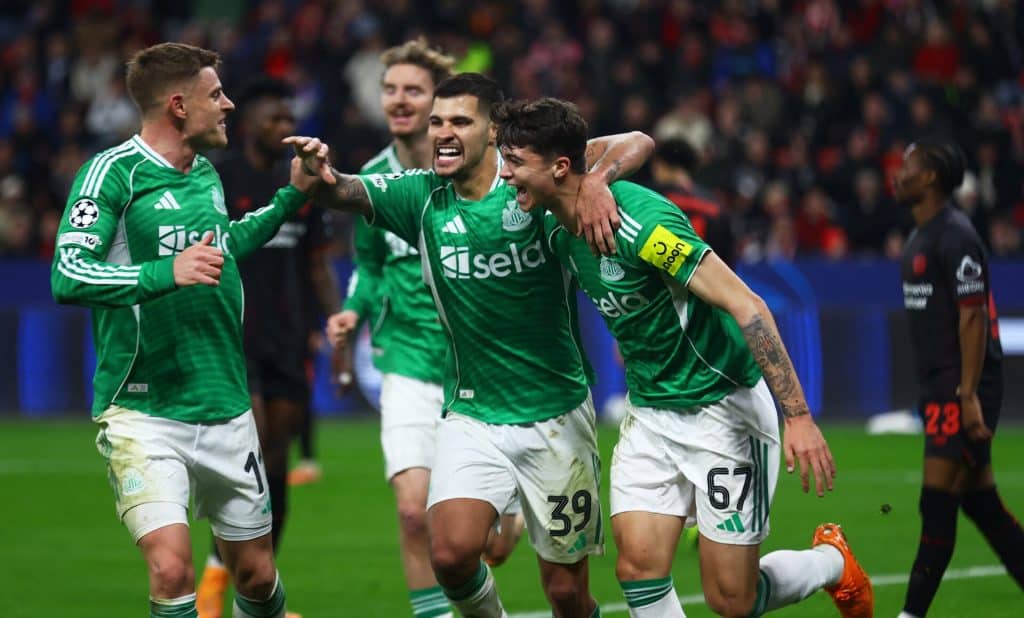Soccer players celebrating after scoring a goal in a high-intensity match.