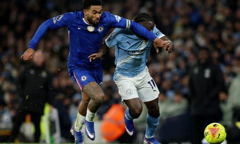 A Chelsea player and a Manchester City player compete fiercely for control of the ball during a high-intensity soccer game.