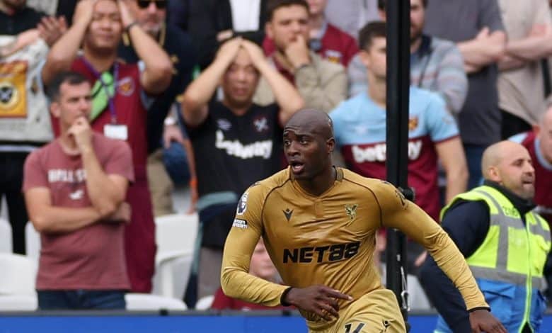 Vibrant action shot of a professional soccer player in golden jersey during a match, with an attentive crowd in the background capturing the intensity and excitement of the game.