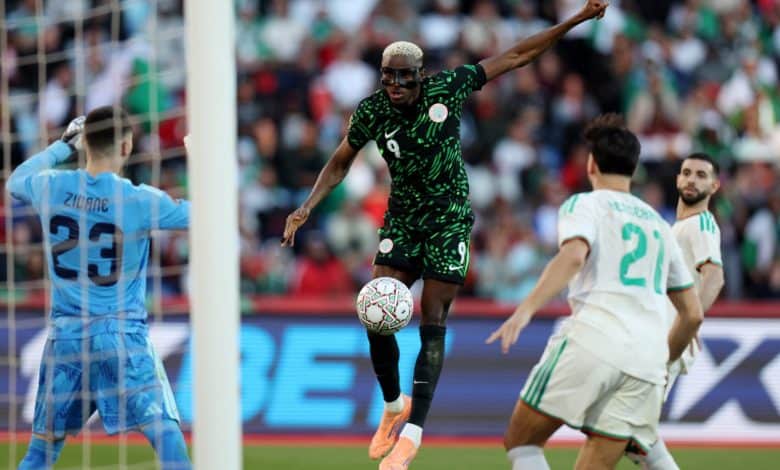 Ethiopian soccer player in green jersey scoring a goal as opponents and goalkeeper look on during exciting match.
