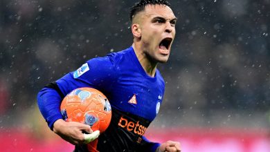 An energetic soccer player passionately celebrating on the field during a rainstorm, clutching the ball, showcasing intense emotion, athleticism, and determination in a competitive match.